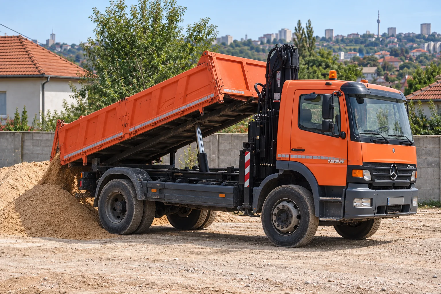 Narandžasti Mercedes kiper pri istovaru peska